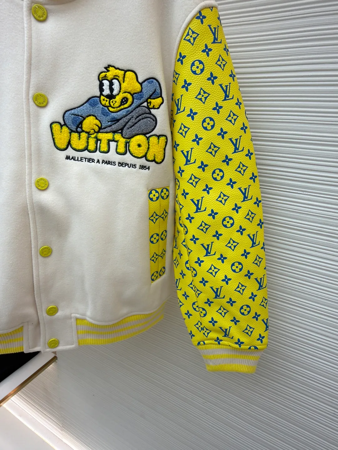 LOUIS VUITTON Cartoon polka dot dog embroidered all-over printed leather sleeves baseball jacket ●Original version: Purchased and developed by 35899 ●Item number: 1681207-C15 ●Fabric: cupro silk fabric ●Technology: embroidery process ●Color: yellow ●Version: fitted version ●Weight: about 1045 grams ●Size: S-M-L-XL ●Description: The polka-dot puppy towel stitch embroidery + cotton flat embroidery is composed of two sets of yarns of different sizes. The visual effect is more three-dimensional. It is matched with cupro silk + cotton blended lining, and is matched with a molded and customized aluminum alloy material with a logo spray-painted four-button buckle + a hanging plated back collar made of white copper and a white gold hardware chain. The sleeves are made of imported calfskin, and the back embroidery requires multiple processes to achieve the effect. The overall routing is straight and delicate, the fabric is comfortable and soft, and the colors are consistent without color difference. It can be matched with the same style to create a fashionable look and control various occasions. Customized accessories, complete with three standards, same style for men and women!